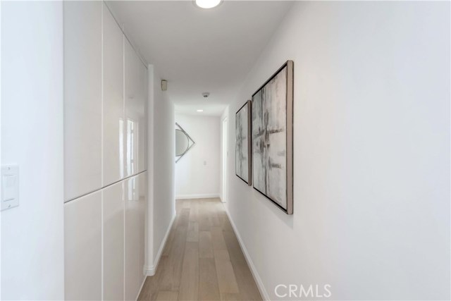 Hallway to bedrooms, built-in cabinets on left side.