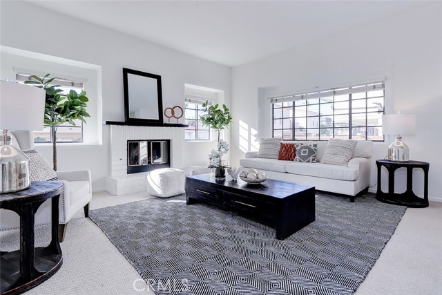 Light filled living room in this end unit, with a fireplace and private patio just outside!