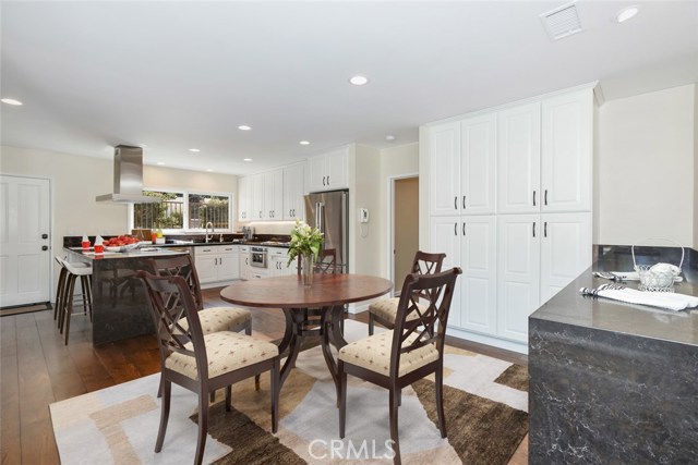 Different perspective of kitchen showing extensive cabinetry and more counter space as well as breakfast nook.