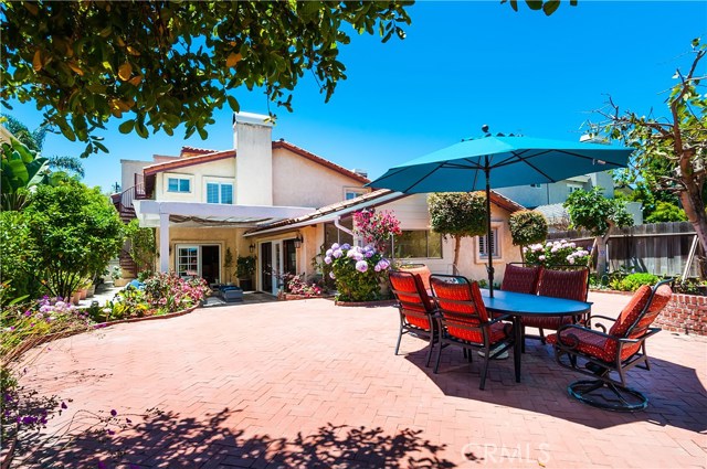 Amazing backyard is brick paved with continuous flower beds and shade trees, plus a 23 x 23 covered patio. You can see the spiral staircase that leads to the 3rd level of the interior.