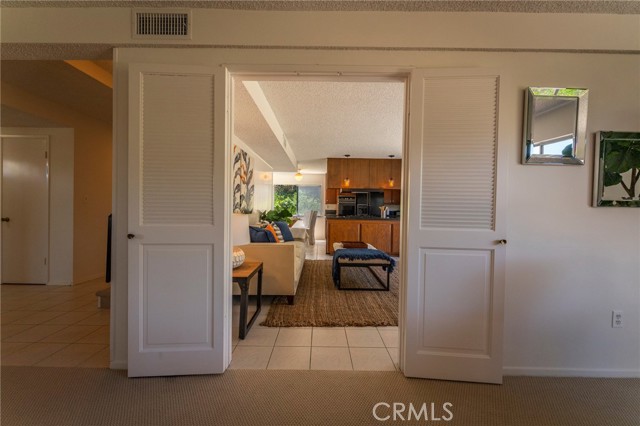 Entryway from living and formal dining area into kitchen + den + breakfast nook.  Stairway up is to your left (you can just make out the black stairway railing).