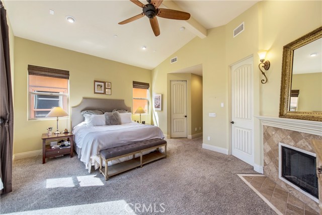 Beautiful master suite with fireplace, vaulted ceilings, recessed lights, and wonderful natural light