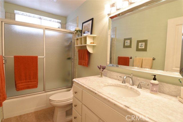 Hall bathroom near the kitchen and bedroom #2 & 3 has beautiful new vanity with Carrara marble counter, new sink, faucet, lighting, tile flooring.