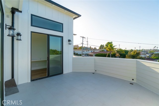 View of upper outdoor deck facing front of house.  Sliding door leads into computer/office area.