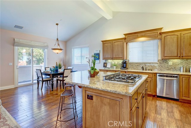 A cook's kitchen with granite counters, breakfast bar, all stainless appliances, tons of cabinet storage space and counter top space.