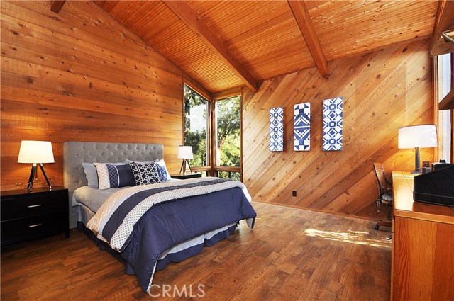 Bedroom 5 with vaulted ceiling and wood floors