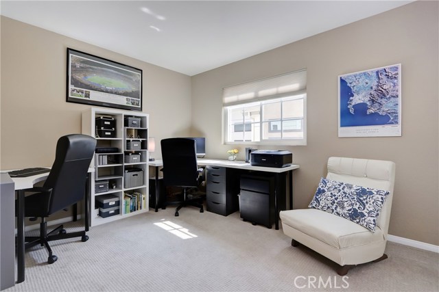 this third sunny and bright bedroom is currently being used as a dual office.