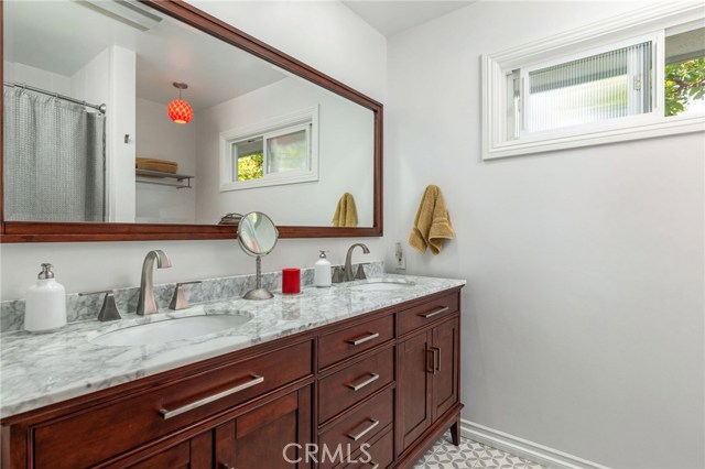 Completely remodeled 2nd bathroom has vanity with 2 sinks, beautiful tiled floors and tub/shower.