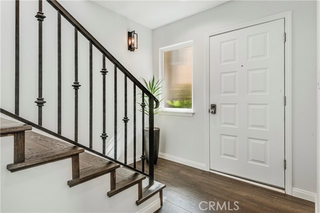 Bright entry with wrought iron railing and new designer wall sconce lighting.