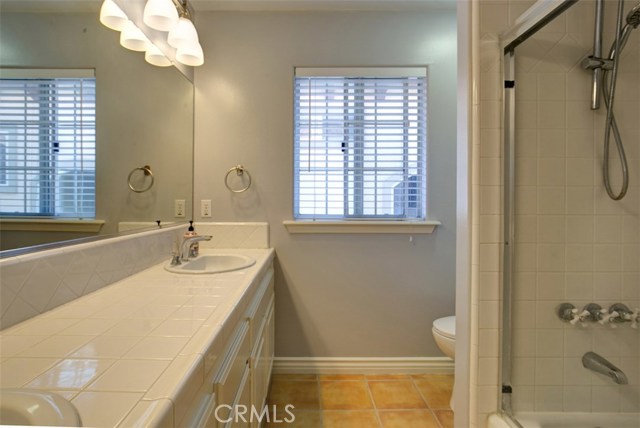 Common bath adjacent bedrooms features twin sinks and full shower/tub enclosure