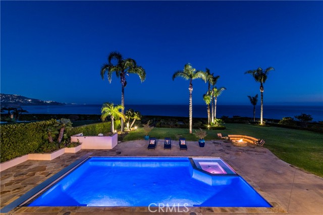 Stunning view of the pool, jacuzzi and fire pit at night