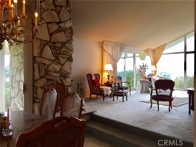 Living room and dining room connected to create great room with tall cathedral ceilings.