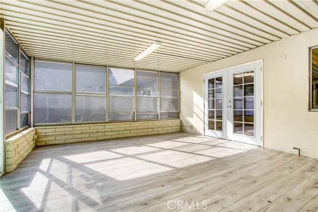 Enclosed Sunroom with new Laminate flooring. New sliding doors to the out side patio area and new french doors too inside.