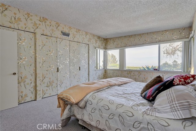 MASTER BEDROOM WITH LOTS OF CLOSET SPACE WITH VIEWS OF THE BACKYARD, POOL, AND OCEAN VIEWS.