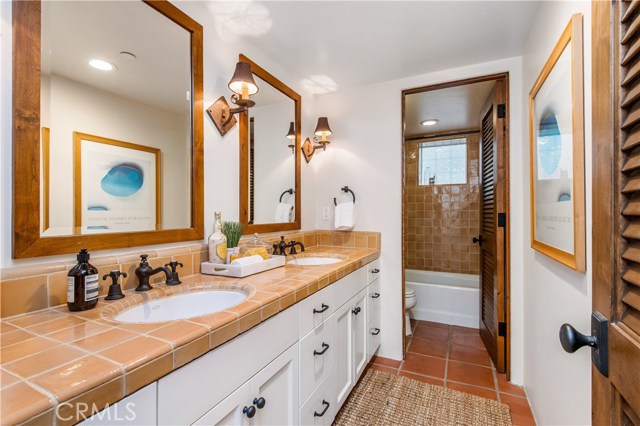 Full bathroom located on the lower level features dual sinks and private bathing experience.