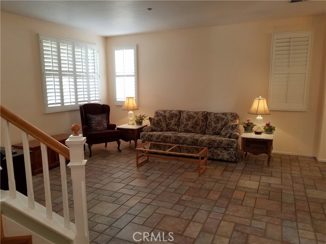 Step Into the Spacious Living Room Elegantly Appointed With Tile Flooring and Plantation Shutters Throughout.