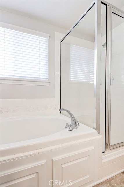 Master bathroom includes an updated luxurious soaking tub and separate walk-in shower with glass enclosure.