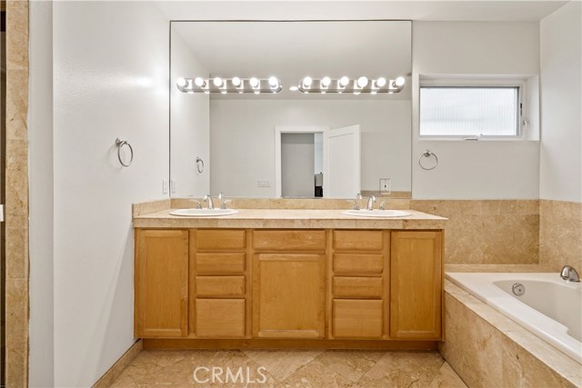 En-suite primary bathroom with double vanity and separate jacuzzi-style tub and shower