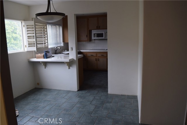 Kitchen with bar area and separate dining area with plantation shutters.