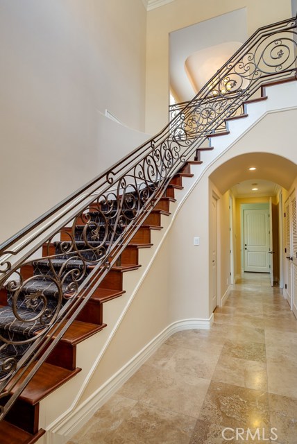 Dramatic 2-story entry with spiral staircase with hardwood steps and wrought iron rails.