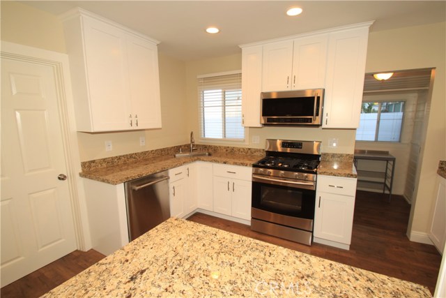 Another view of the kitchen with granite counters, eat in bar table for 4, and nice appliances!