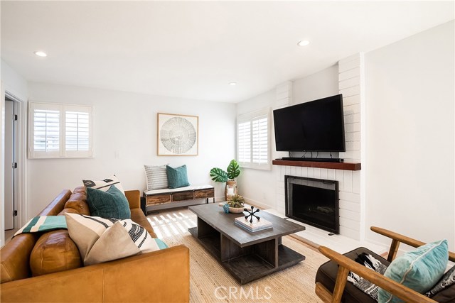 COMFORTABLE FAMILY ROOM FEATURES BRICK FIREPLACE AND PLANTATION SHUTTERS.