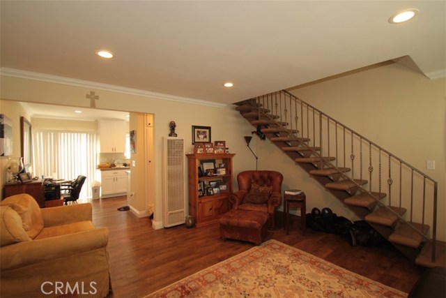 Another view of unit #B.  Sliding door at rear opens to the patio & rear yard to the left.  All newer railings lead upstairs.  ½ bath is between the living room and kitchen.