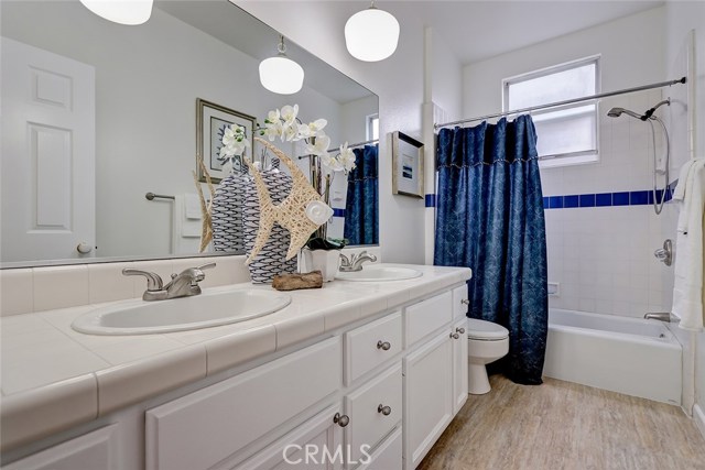 Large full bath on entry level with dual sinks and newly painted cabinets with hardware.
