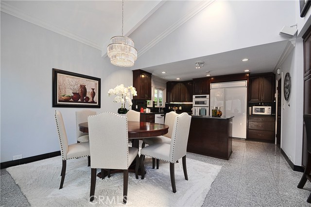 Bright eat-in kitchen with natural stone flooring and granite counters and cooktop island.