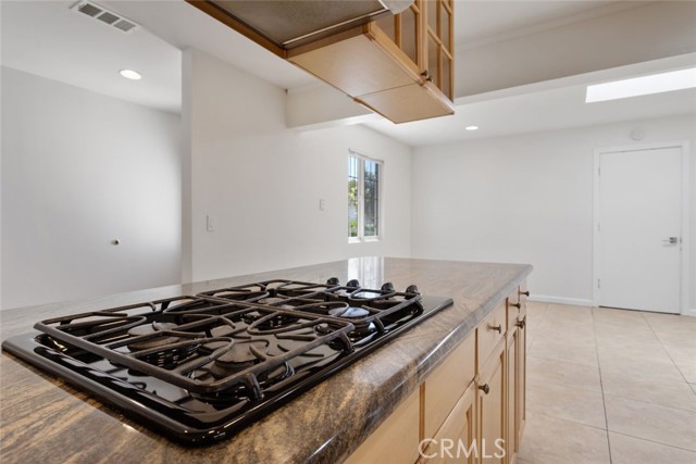 Built in stove in kitchen and family room in the background.