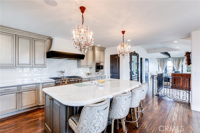 The large kitchen island offers a breakfast counter, prep area and sink .