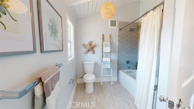 here is the ensuite bathroom of the second bedroom. Large shower/tub combination, wood cathedral ceiling gives the room an open airy feeling. the color of the floor and shower finishes will never go out of style.