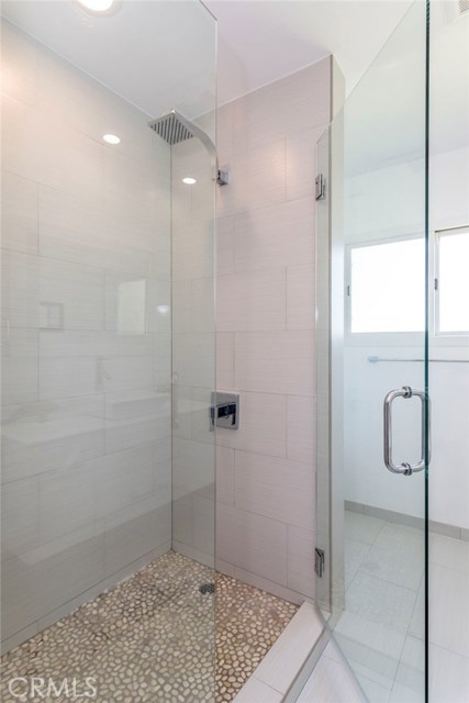 With tasteful touches found throughout, this full bath for the bedrooms spaces offers clean white cabinetry and a spacious shower.