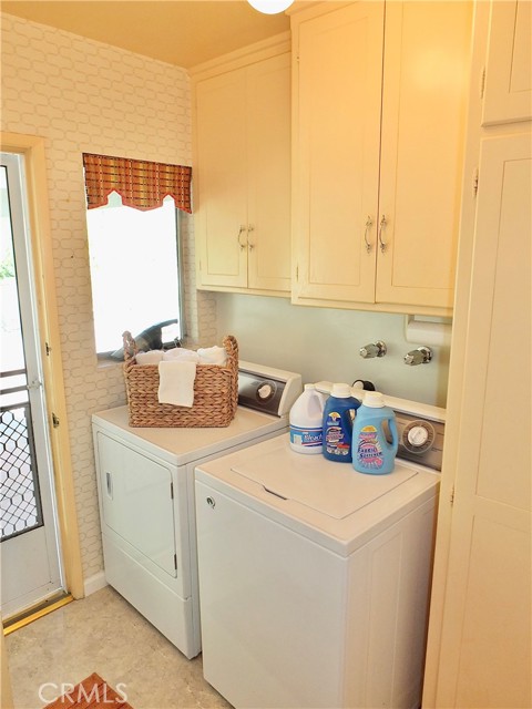 The laundry room is conveniently  tucked away behind the kitchen across from a   door leading to the garage and back yard.