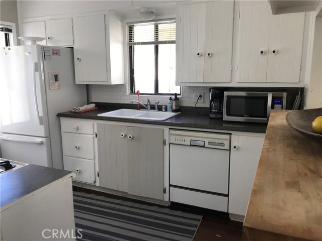 Kitchen with butcher block counter area. Kitchen door leads to the back patio.