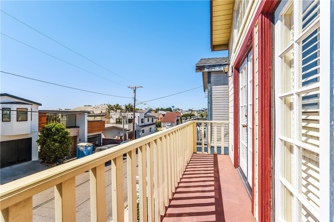 The front balcony off of the living room, spans the width of the front of the house. This is the view looking to the North down the quiet street with many recently remodeled and new homes. The view to the West takes in the sunset views and the ocean between the houses across the street.