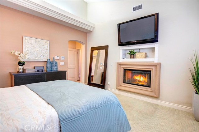 Peaceful and quiet master bedroom suite with vaulted ceilings, ceiling fan, and the 2nd of two fireplaces.