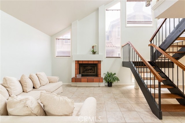 Sun drenched living room with fireplace and vaulted ceiling