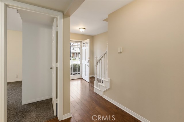 Downstairs view of front foyer and hall leading to two bedrooms and a full bath.