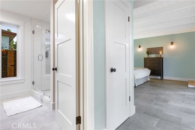 The gorgeous spa-like bathroom with custom Field Tile in White from Mission Tile West on shower walls,
Chevron Glass Tile by Artistic Tile, Swingin’ Chevron Be Bop White Glass Mosaic on niche
Calacatta Gold Broken Joint Mosaic polished stone by Artistic Tile on shower floors, with Laverton Nieve hexagon tiles on bathroom flooring, and Rift white oak vanity and custom cabinet by Coastal Cabinets.