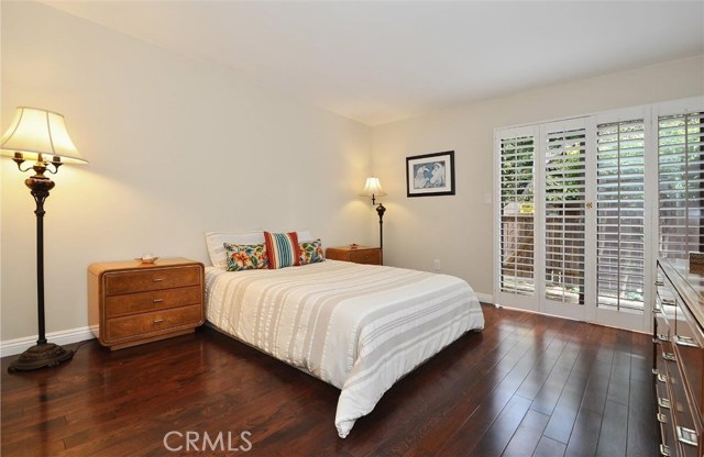 Master bedroom with warm wood floors and Plantation shutters.