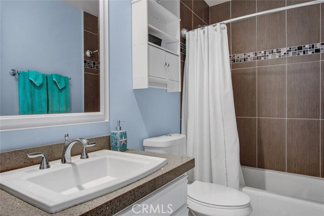 Hall bath has quartz counter top, custom shower tile.