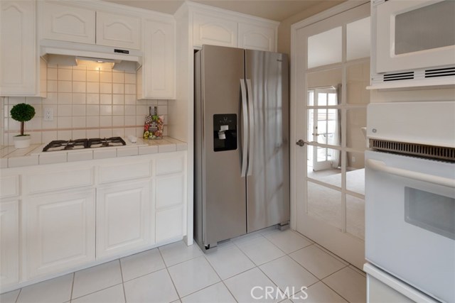 Kitchen has a door that leads to formal dining, living room and outdoor patios