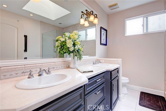 En-suite master bathroom with stone countertop, jetted tub, walk-in shower, and skylight which brings tons of natural light!