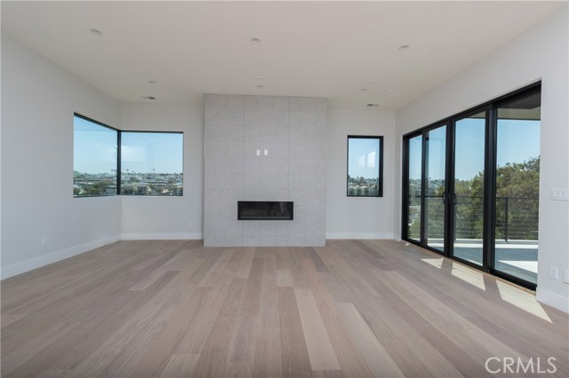 Gorgeous natural sunlight with stunning custom fireplace and hardwood flooring with views