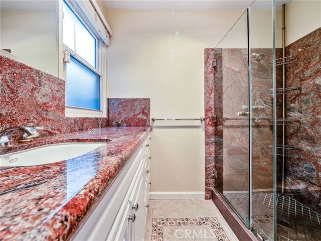 The remodeled master bathroom with large shower, granite finishes.