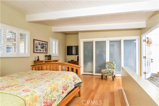 The upper level master bedroom has beamed ceilings, maple floors and 2 large closets.