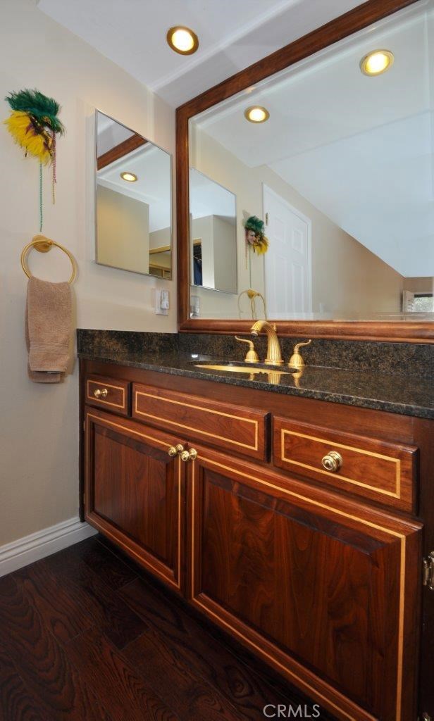 View of  one of the TWO vanities in the Master Suite. Granite counter top, custom cabinetry and brass fixtures + sink.