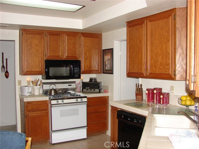 A LOOK INSIDE THE LARGE KITCHEN: HIGH CEILINGS, TILED FLOOR AND SO MUCH COUNTER SPACE AND CUPBOARDS.