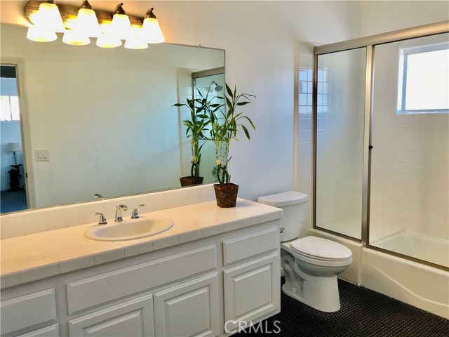 Newer fixtures, nice glass enclosure, a full shower-bath with sitting area, window and high ceilings for increased ventilation highlight the hall bathroom upstairs.